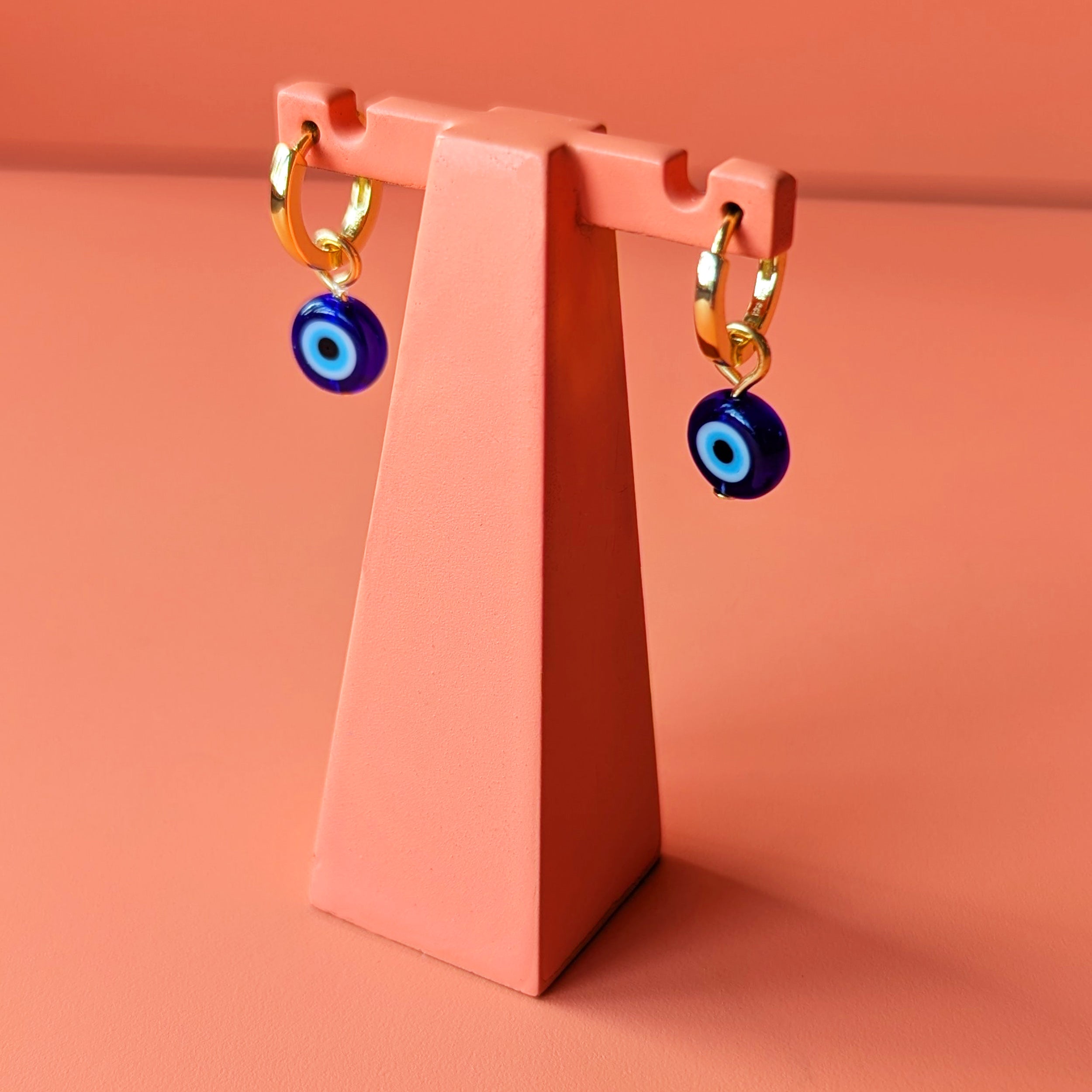Evil eye charm on gold huggie hoops